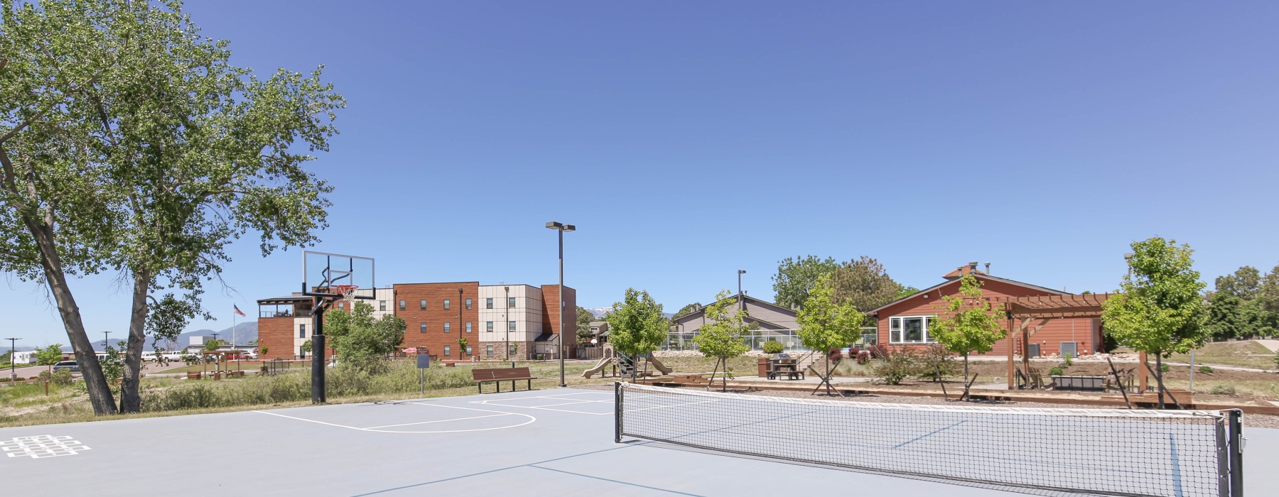 Sports court with nets facing building and trees