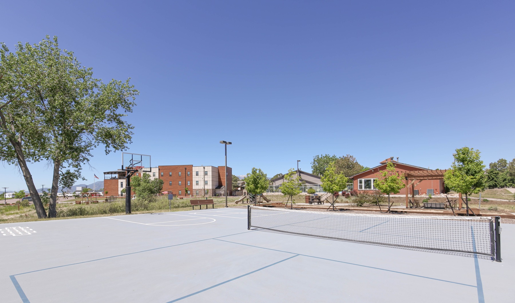 Play a game at our sports court Sports court with nets facing building and trees
