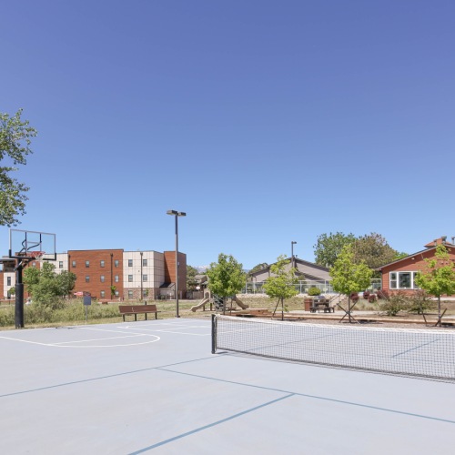 Play a game at our sports court Sports court with nets facing building and trees