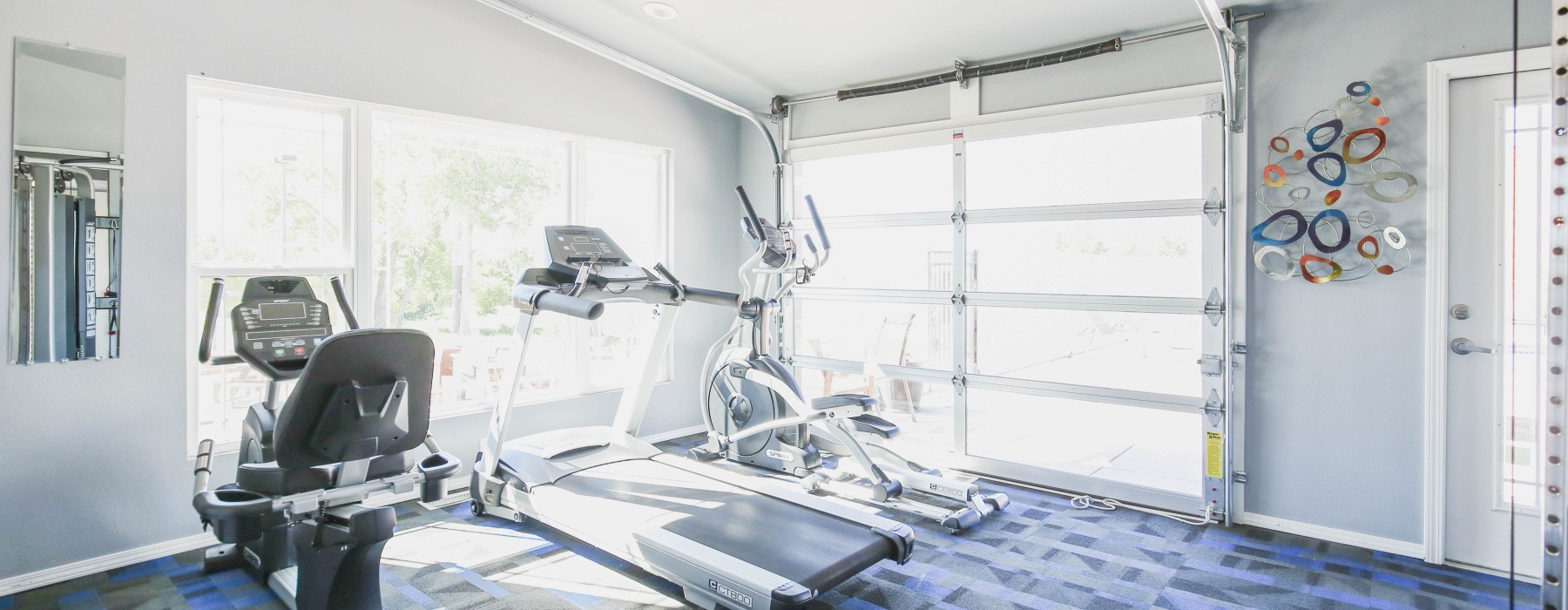 Fitness center with equipment and garage doors