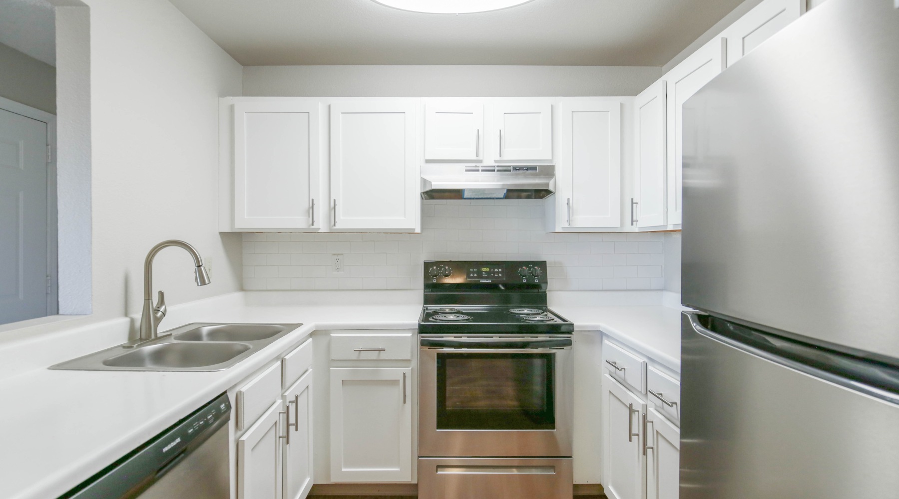 Whip up a meal in your upgraded kitchen Kitchen with white cabinets and stainless steel appliances