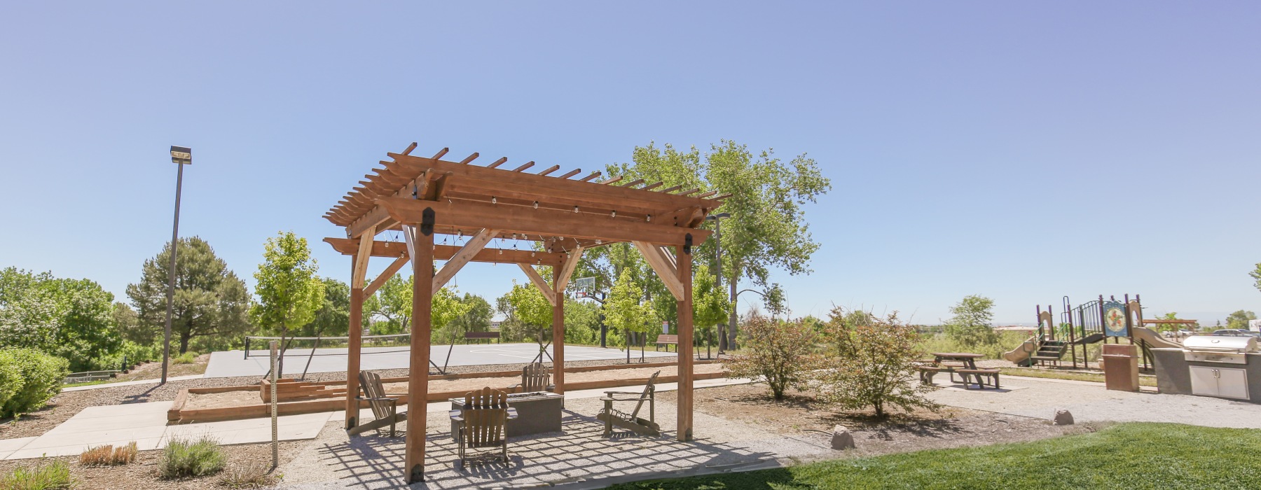 Greenspace with pergola, firepit, and sports courts in the back