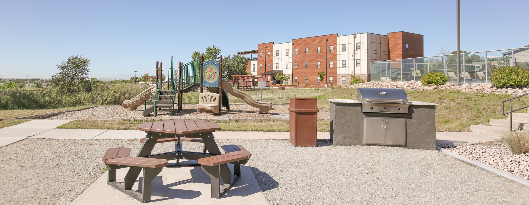 Grilling area with grills and table with building in the background