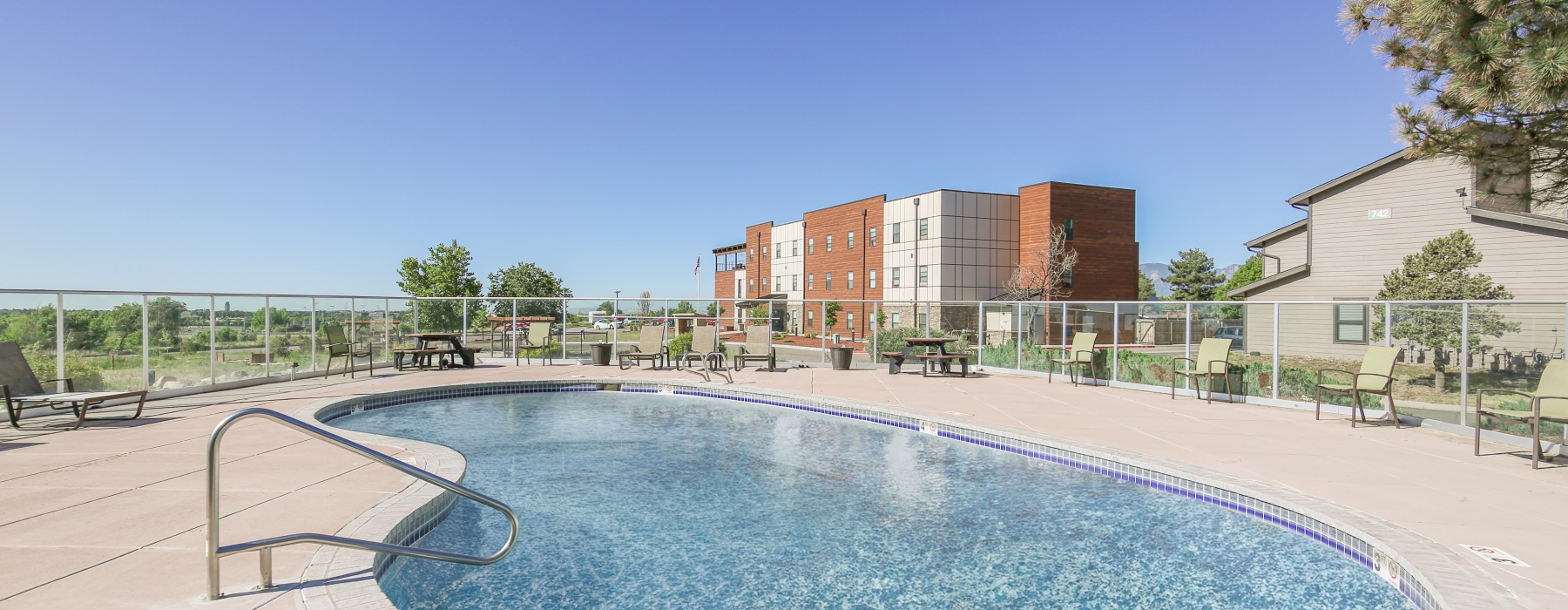 Swimming pool with sundeck and building in the background